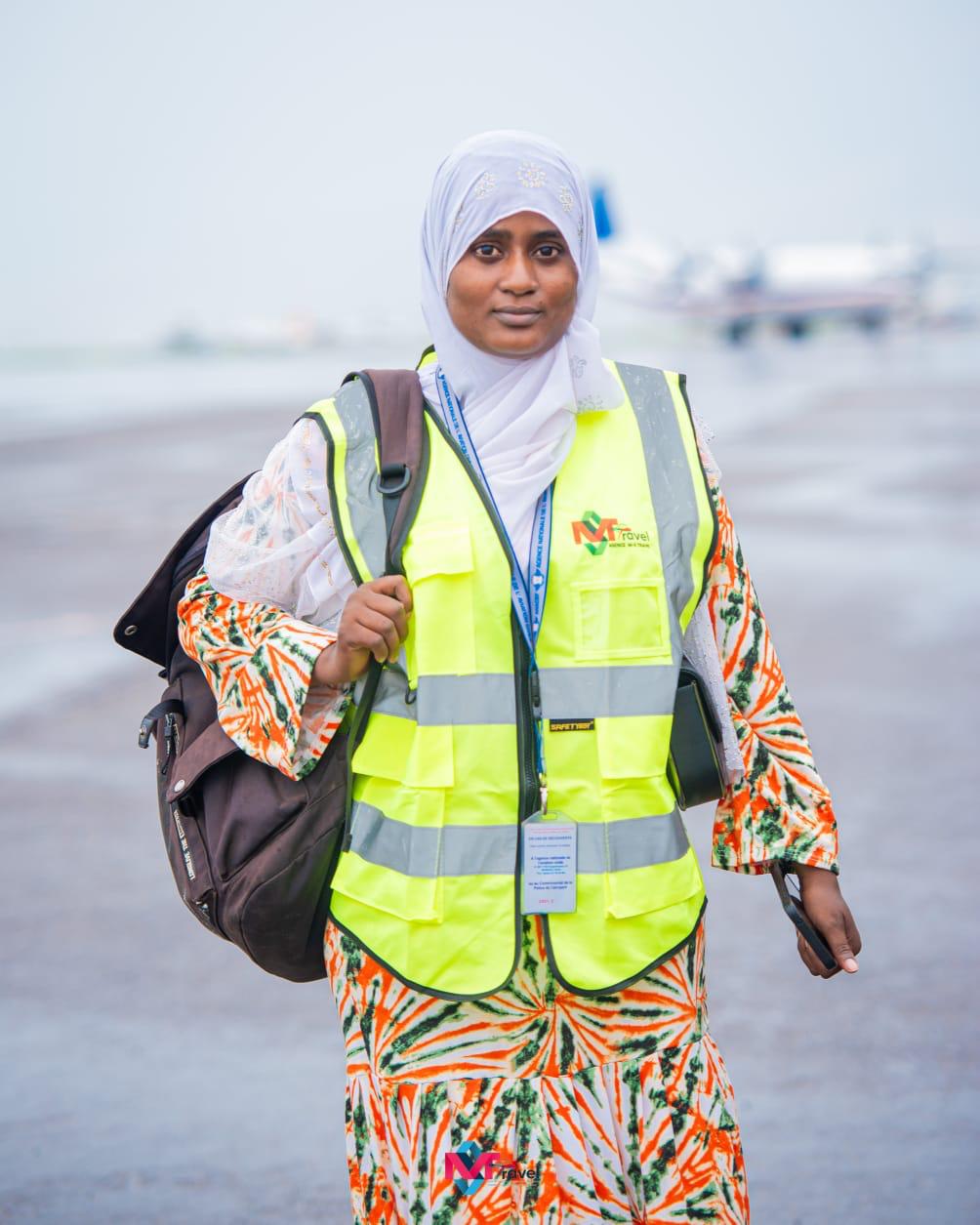 Agent M-S TRAVEL en gilet jaune souriante sur le tarmac