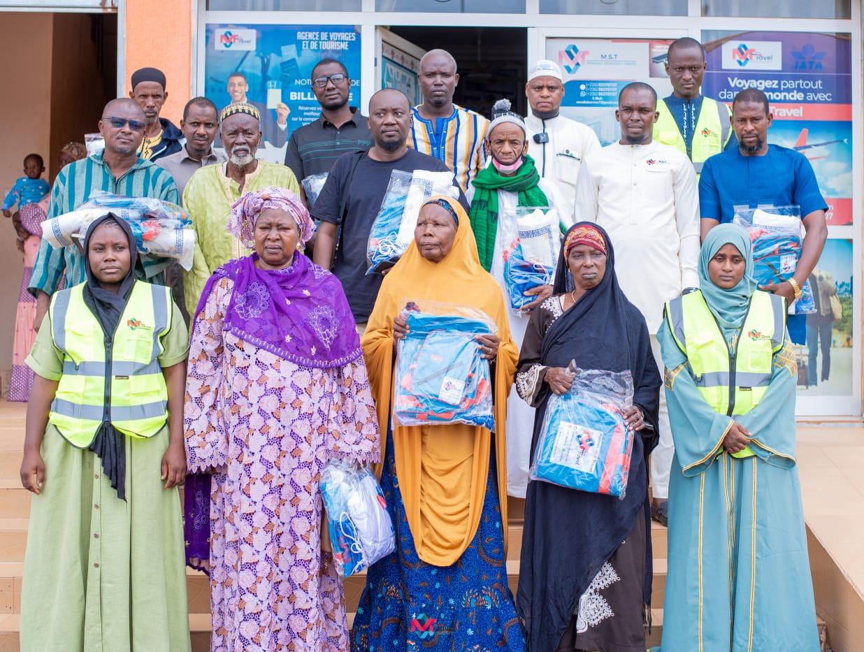 Groupe de clients devant l'agence M-S TRAVEL tenant leurs kits de voyage