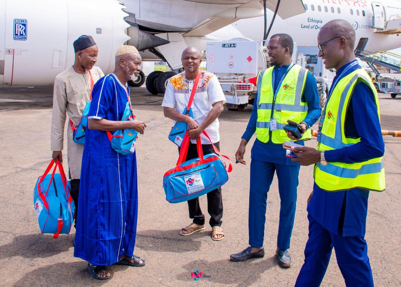 Voyageurs et agents en gilets jaunes sur le tarmac devant un avion