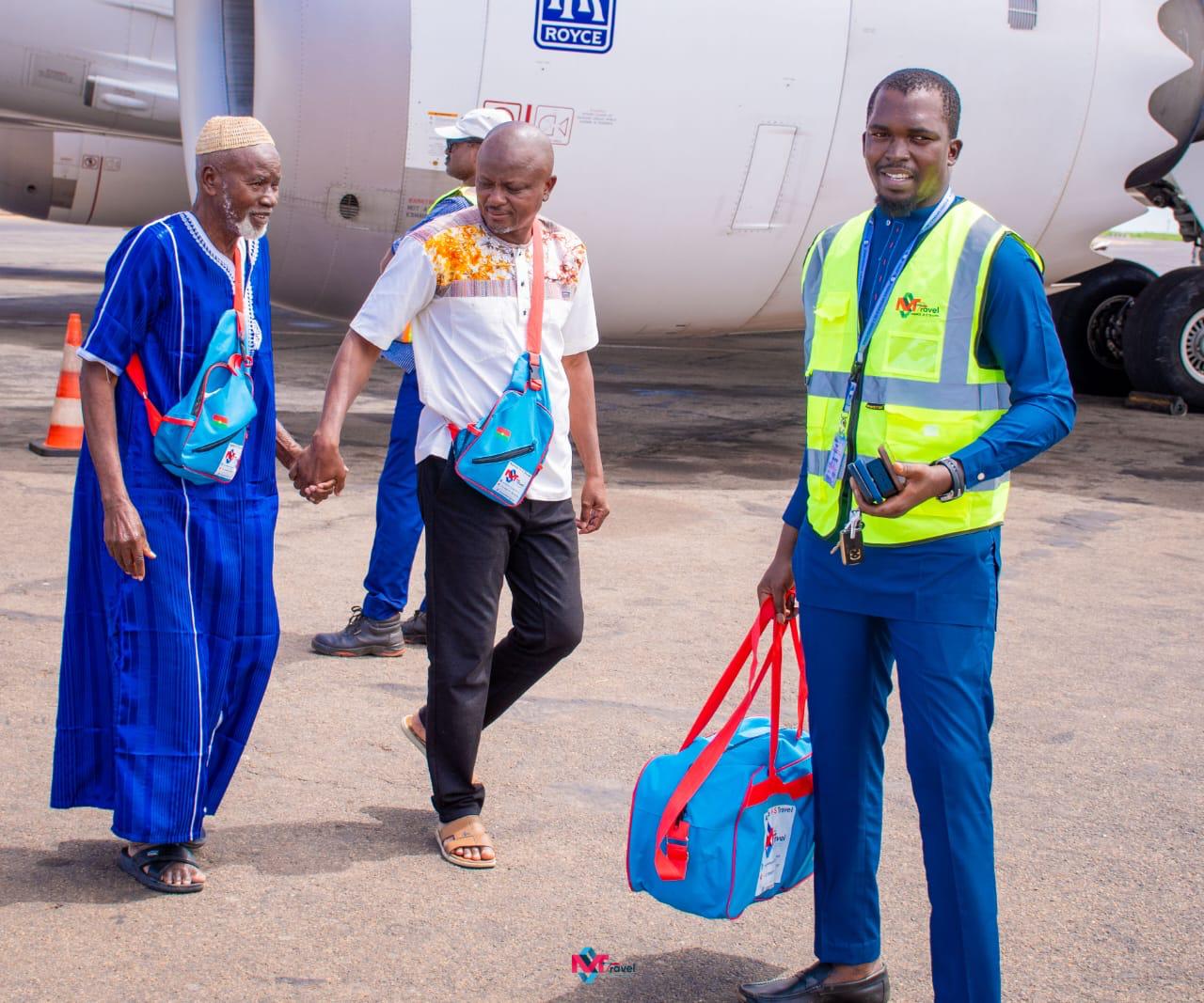 Voyageurs souriants accompagnés sur le tarmac par un agent M-S TRAVEL en gilet jaune